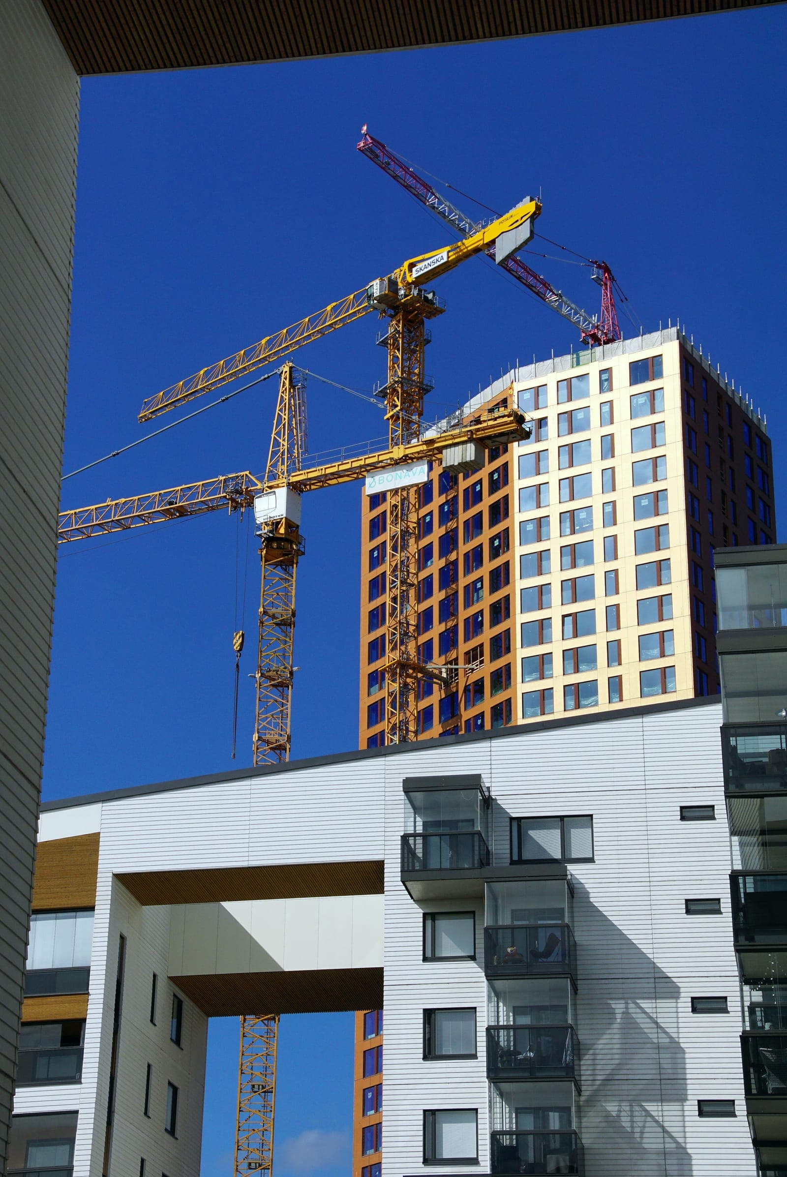 Modern apartment building under construction with tower crane
