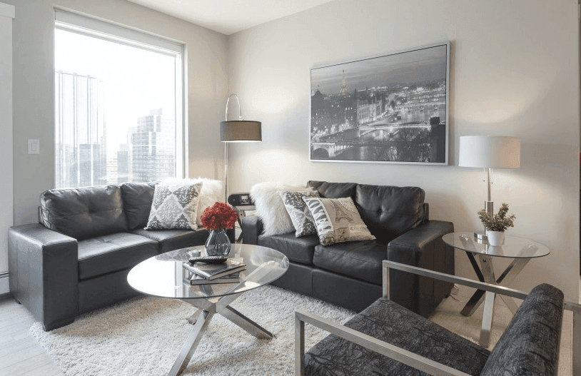 A fully furnished suite at Princeton Suites in Edmonton, showing a modern living and dining area ready for move-in